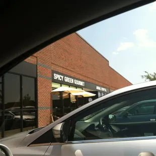 a silver car parked in front of a store