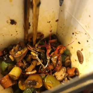 a bowl of stir fry with chopsticks