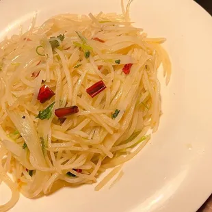 a white plate of noodles with peppers