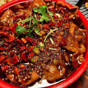 a red bowl of food on a wooden table