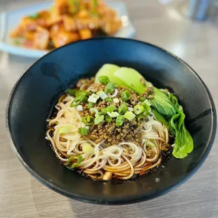 a bowl of noodles with meat and vegetables