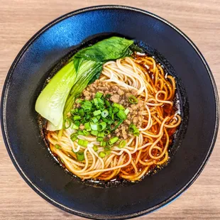 a bowl of noodles with meat and vegetables