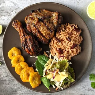 Jerk Chicken Plate. Two pieces of grilled chicken marinated in spicy jerk seasoning. with plantains, rice and peas.
