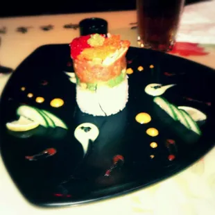 a sushi dish on a black plate