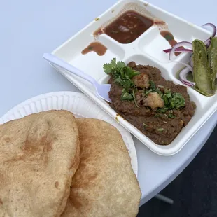a plate of food and a container of pickles
