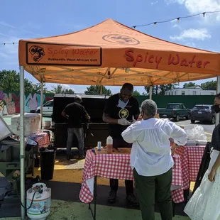 a group of people standing under a tent