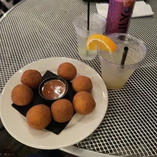 a plate of deep fried donuts and a drink