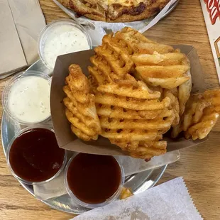 a pizza and french fries on a table