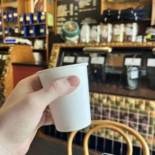 Perfectly balanced, custom espresso drink with the shop in the background