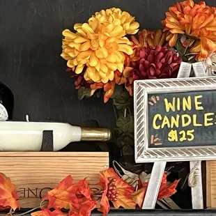 a chalkboard sign with wine candles and flowers