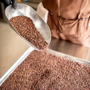 a person pouring chocolate into a pan