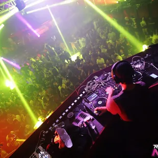 a dj mixing in front of a crowd at a nightclub