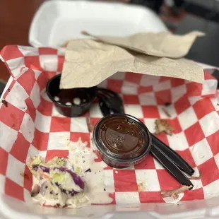 The remnants of a pulled pork sandwich and coleslaw.
