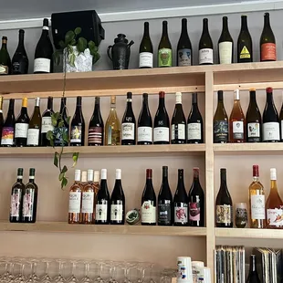 a wall of wine bottles and glasses