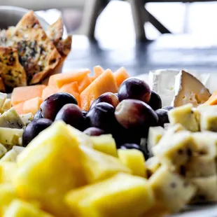 a plate of cheese, grapes, and crackers