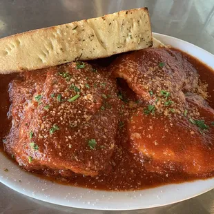 EGGPLANT PARMIGIANA (five layers of lightly battered and fried eggplant, mozzarella, and tomato gravy) with cheese ravioli and garlic bread