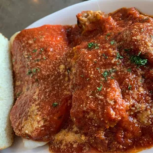 EGGPLANT PARMIGIANA (five layers of lightly battered and fried eggplant, mozzarella, and tomato gravy) with cheese ravioli and garlic bread