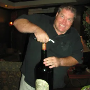 a man opening a bottle of wine