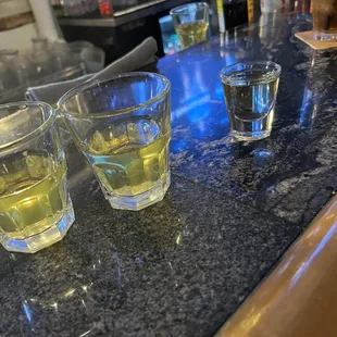 three shot glasses on a bar