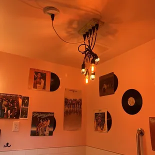 a bathroom with a light fixture and pictures on the wall