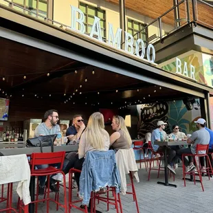 a group of people sitting outside a bar