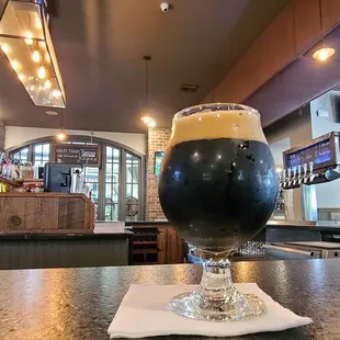 a glass of beer on a bar