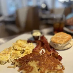 Scrambled eggs, hash browns, bacon and biscuit