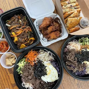 Japchae noodles, 5pc original crispy chicken wings, Seafood Pancake, and two beef bibimbap