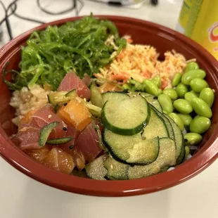 Medium poke bowl with sushi rice (at the bottom) with ahi tuna, salmon, spicy crab, cucumber, edamame and goma wakake  (seaweed salad)!