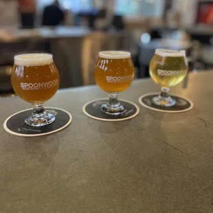 three glasses of beer on a bar