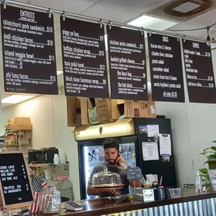 a man behind a counter in a restaurant