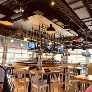 a sports bar with wooden tables and chairs