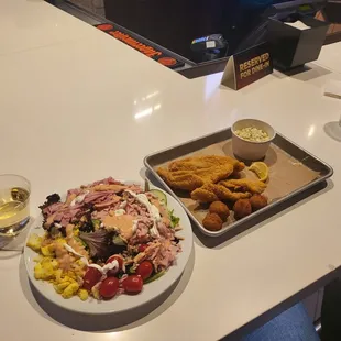 Salad, wine, and fish platter.