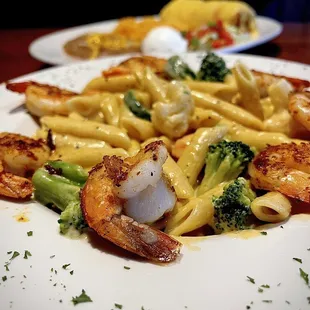 a plate of pasta with shrimp and broccoli