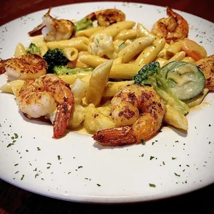 a plate of pasta with shrimp and broccoli