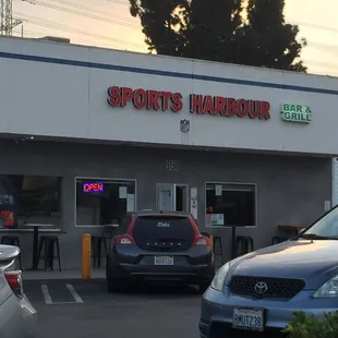 a car parked in front of a sports bar