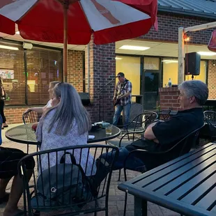 a group of people sitting at tables outside a coca cola store