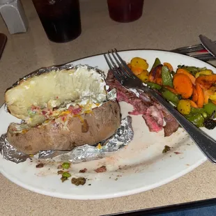 Rare rib eye with roasted veggies and loaded baked potato