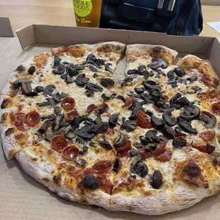 a pizza with pepperoni, olives, and cheese
