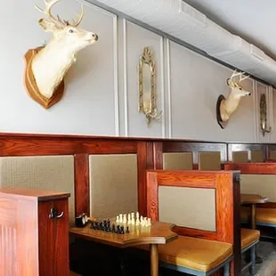 a row of booth seating with deer heads on the wall