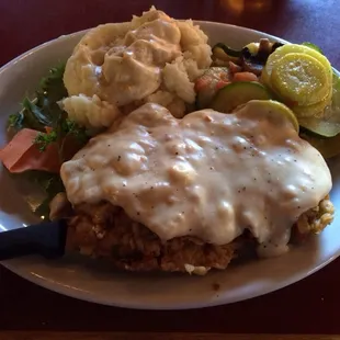 The Country Boy Chicken Fried Steak with country gravy and mashed potatoes .