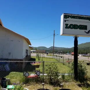 Sign above dog area and highway with elk close by