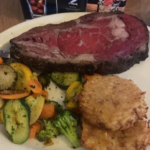 Prime rib dinner with potato pancakes and veggies