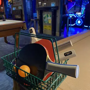 a racket and ping pong paddles in a basket