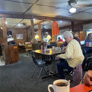 a man sitting at a table with a cup of coffee