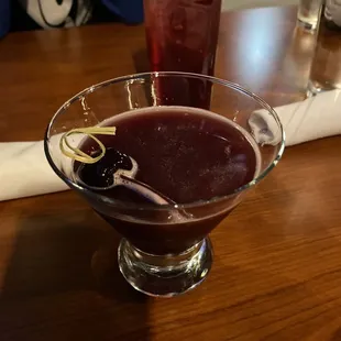 a cocktail in a glass with a garnish