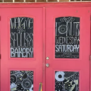 two red doors with chalk drawings on them