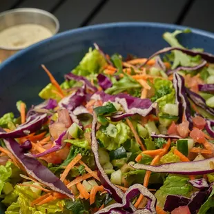 Kale, Romaine, fresh garlic bread croutons, vegan, Parmesan, and pepitas with vegan caper Caesar dressing (dressing contains soy).