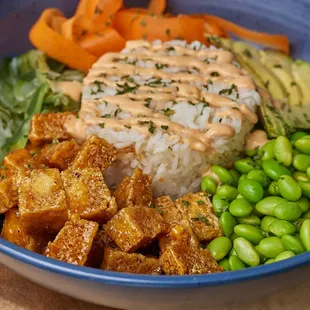 Ginger-soy glazed tofu, pickled cucumber, carrot ribbons, edamame, avocado, nori, crispy shallots, spicy aioli, and green onions over jasmin