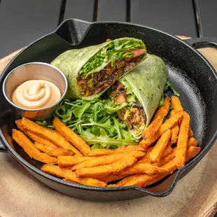 We grilled vegan steak with sautéed red onions, Romaine /spinach, tomato with chili lime sauce on a spinach wrap, vegan cheese,  wheat glute